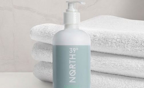 39° North Body Lotion with folded towels on the background