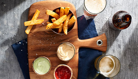 Side Handle Serving Board with fries and dipping sauces on it